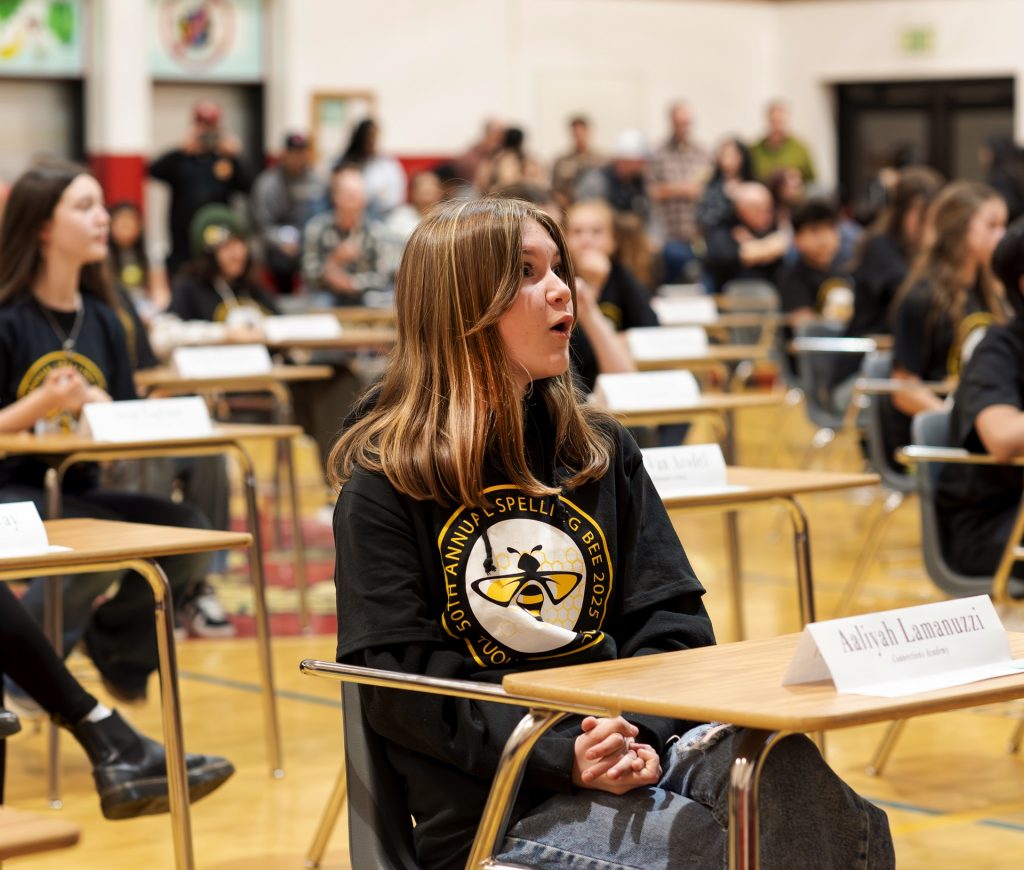 A student reacts during the 50th Annual Tuolumne County Spelling Bee, expressing surprise and excitement.