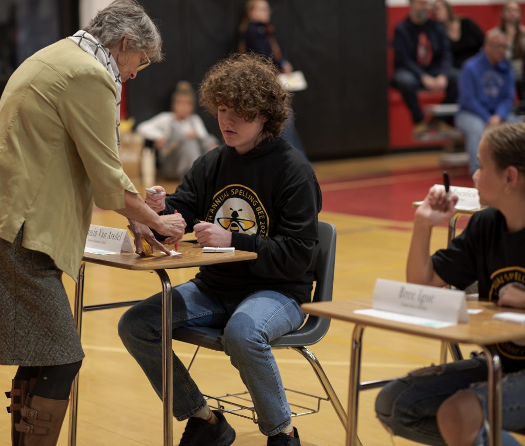 A judge reviews a word with a student at the Tuolumne County Spelling Bee.