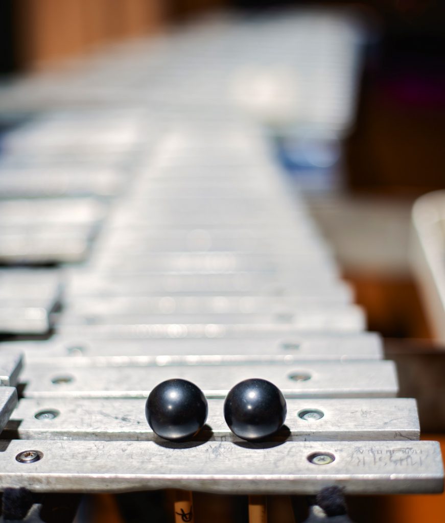 A xylophone with black mallets on top.