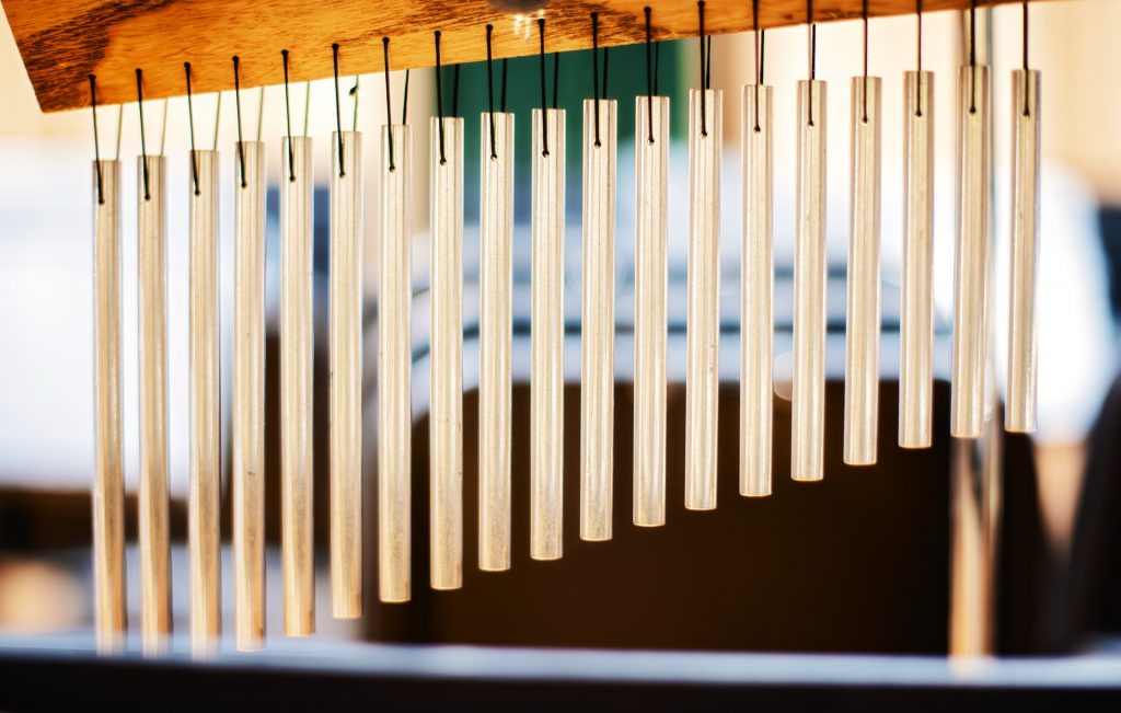 Hanging chimes on a wooden frame.