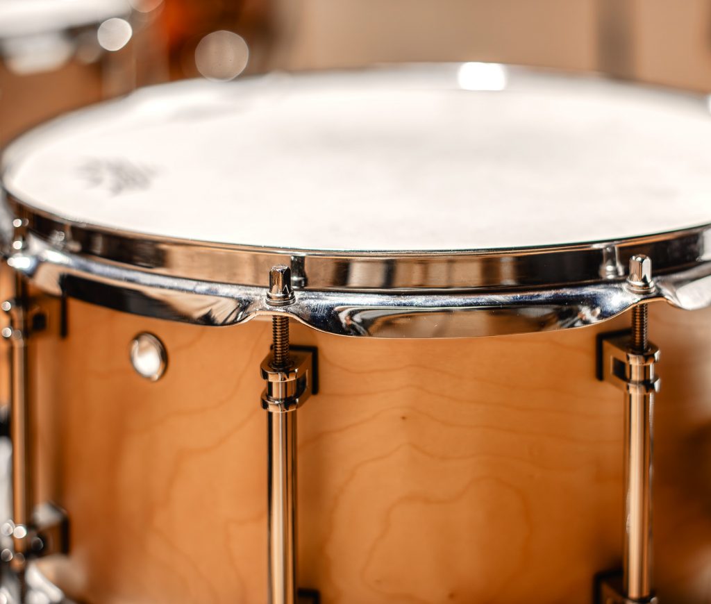 A wooden snare drum with chrome hardware.