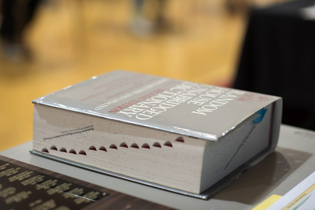 A well-used dictionary sitting on a table at the 50th Annual Tuolumne County Spelling Bee, serving as the official reference.